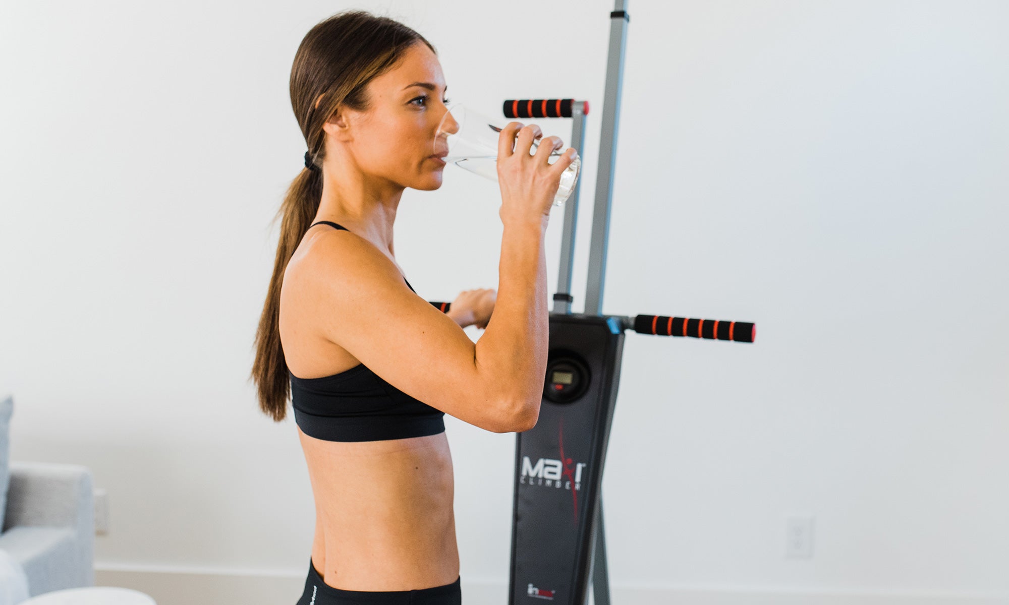 Amanda drinking water after finishing her workout on the MaxiClimber Classic 