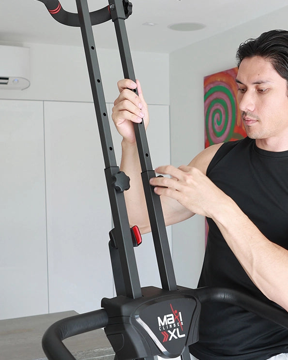 MaxiClimber XL fatures adjustable eight up to 6' 6" / Young man wearing a black shirt adjusting the height of the MaxiClimber XL